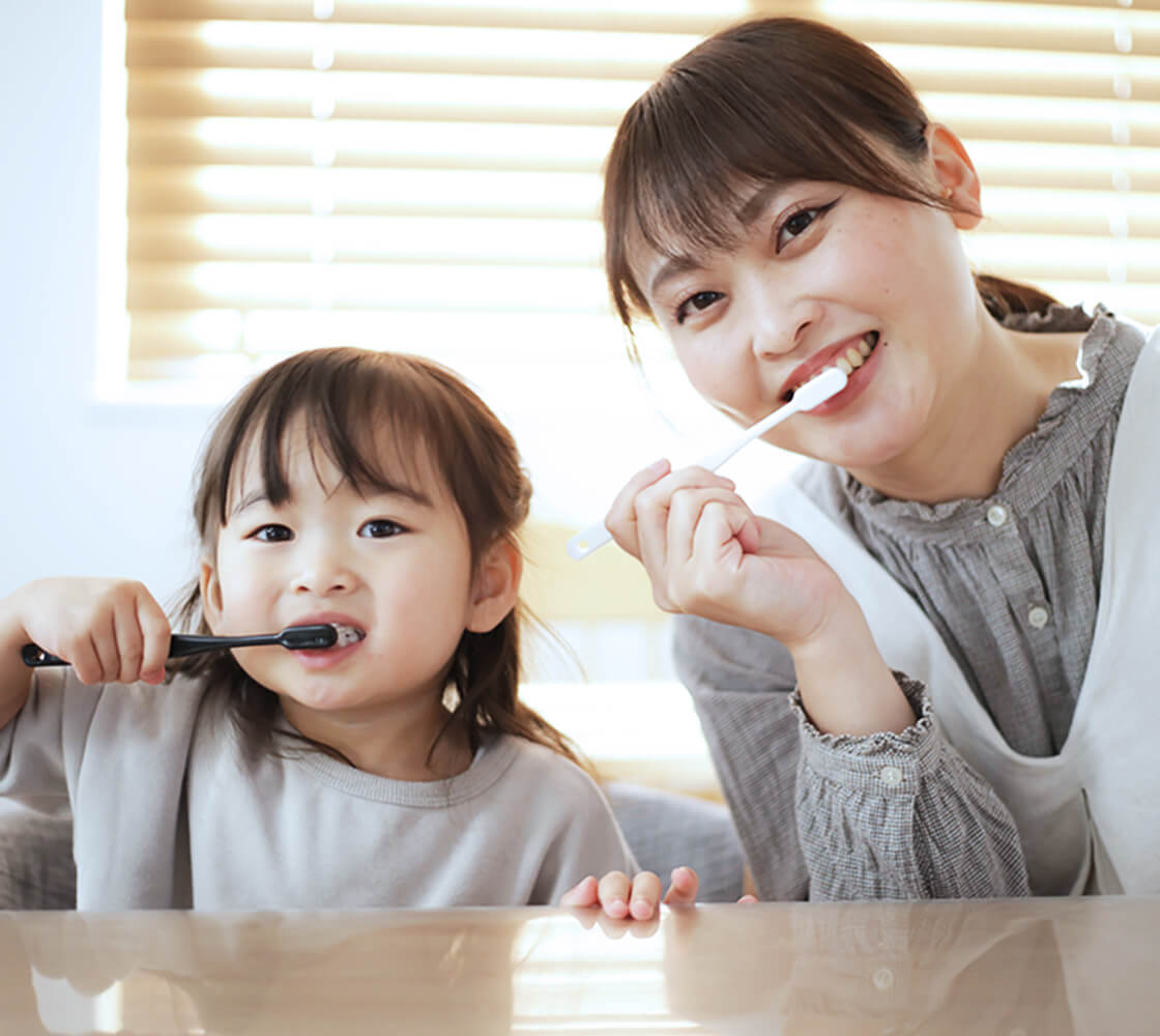 笑顔で歯磨きを行う親子