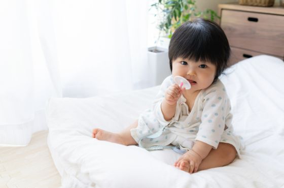 おしゃぶりをもっている赤ちゃん